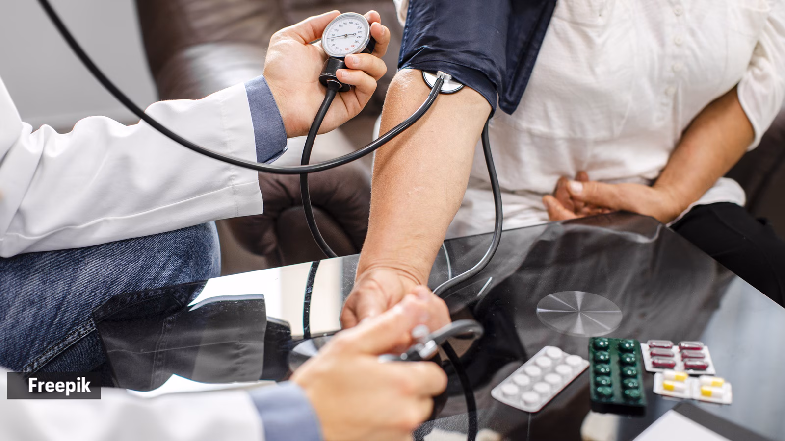 Young male doctor checking blood pressure during a health camp in India