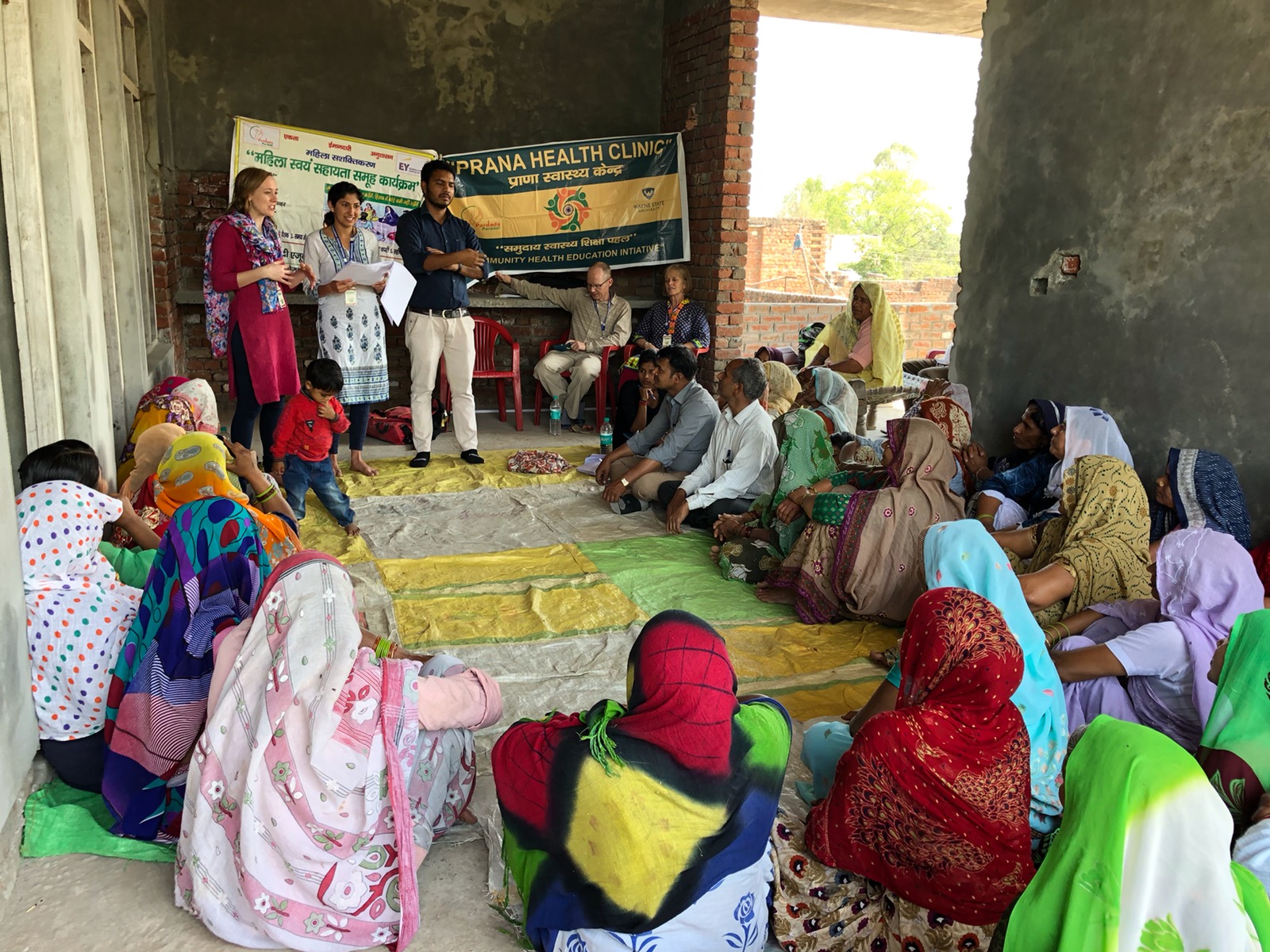 Young male doctor speaking with families about heart health in rural India